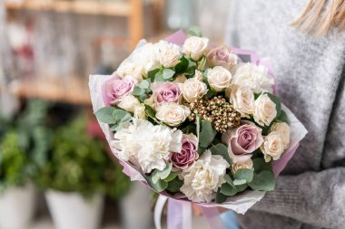 güzel taze karışık çiçekli buket kadın elinde kesilmiş. Çiçekçi Çiçek dükkanında çalışır. Hassas Pastel tonları renk