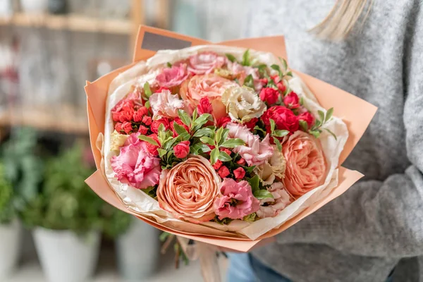 Hermoso ramo fresco cortado de flores mixtas en mano de mujer. el trabajo de la floristería en una floristería — Foto de Stock