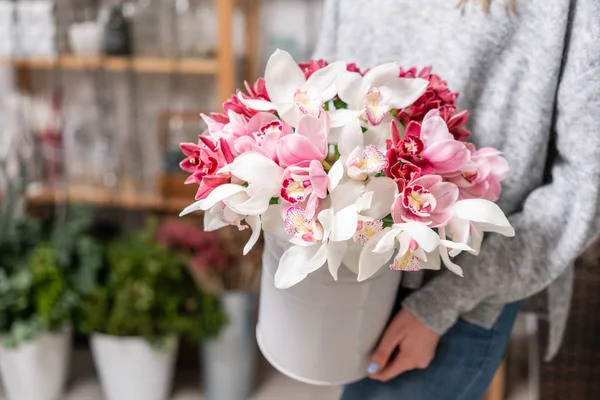 Orquídea japonesa Wanda en jarrones de metal en manos de mujer. Ramo de color rosa pálido. Blanco. el concepto de floristería en una floristería. Fondos de pantalla . — Foto de Stock