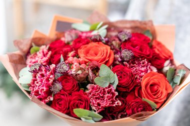 güzel taze karışık çiçekli buket kadın elinde kesilmiş. Çiçekçi Çiçek dükkanında çalışır. Parlak sulu kırmızı renkler