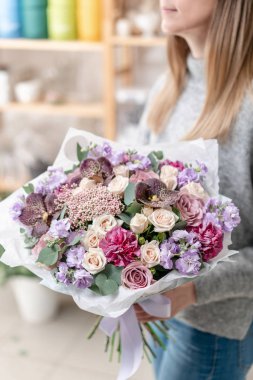güzel taze karışık çiçekli buket kadın elinde kesilmiş. Çiçekçi Çiçek dükkanında çalışır. Hassas Pastel tonları renk
