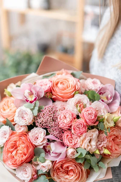 Belo buquê de corte fresco de flores mistas na mão da mulher. o trabalho da florista em uma loja de flores. Delicado tons pastel cor — Fotografia de Stock