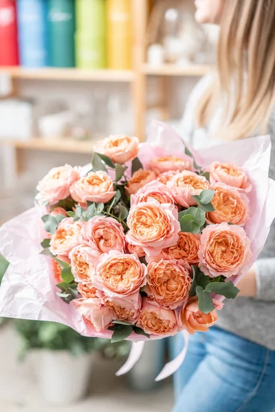 Hermoso ramo fresco cortado de flores mixtas en mano de mujer. el trabajo de la floristería en una floristería — Foto de Stock