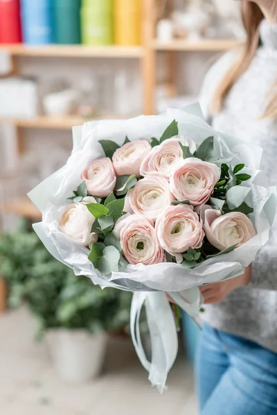 Hermoso ramo fresco cortado de flores mixtas en mano de mujer. el trabajo de la floristería en una floristería — Foto de Stock