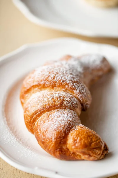 Café capuchino con croissant en plato blanco en restaurante. Desayuno ligero por la mañana, pasteles calientes frescos y frambuesas — Foto de Stock