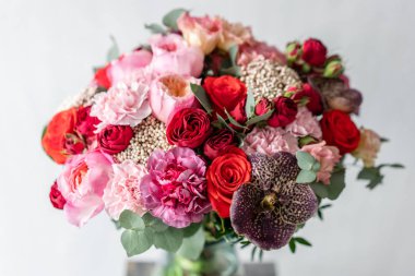 güzel taze ahşap masa üzerinde vazoda karışık çiçekler Buket kesti. . Çiçekçi Çiçek dükkanında çalışır. Hassas Pastel tonları renk