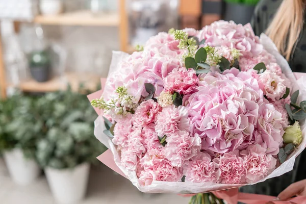 Beautiful fresh cut bouquet of mixed flowers in woman hand. the work of the florist at a flower shop. Delicate Pastel tones color — Stock Photo, Image
