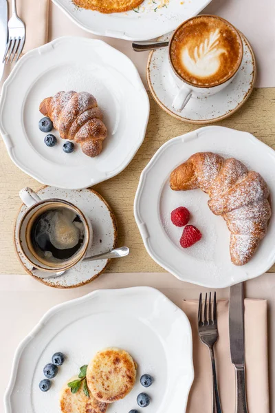 La colazione. Croissant, caffè e molti piatti diversi sul tavolo del ristorante. Frittata - frittata italiana. Omelette con pomodori, avocado, spinaci e formaggio morbido . — Foto Stock