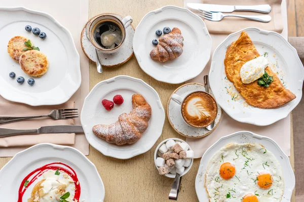 Breakfast. Croissants, coffee and many different dishes on the table in the restaurant. Frittata - italian omelet. Omelette with tomatoes, avocado, spinach and soft cheese. — Stock Photo, Image