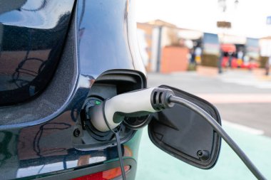 Bir elektrikli araba şarj ediliyor takılı güç kaynağının kapatın. Elektrikli araç şarj istasyonu. Çevre dostu motor kavramı