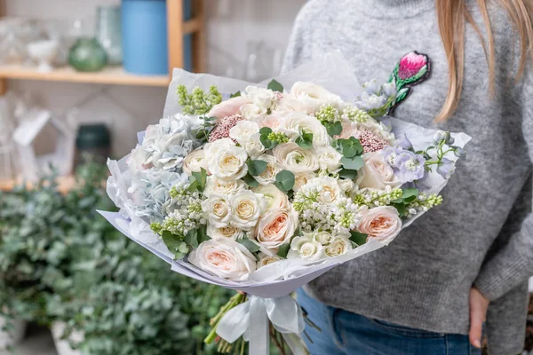 Красивый свежий букет смешанных цветов в руке женщины. работа флориста в цветочном магазине. Нежный цвет пастельных тонов — стоковое фото
