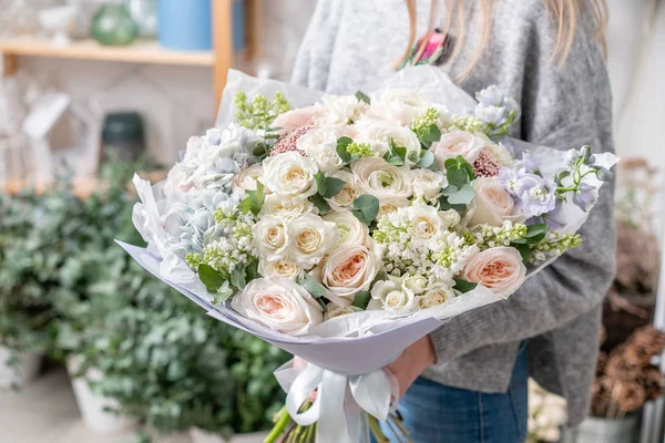 美丽的新鲜切花混合鲜花在女人的手。花店的花商的作品。精致的柔和色调颜色 — 图库照片