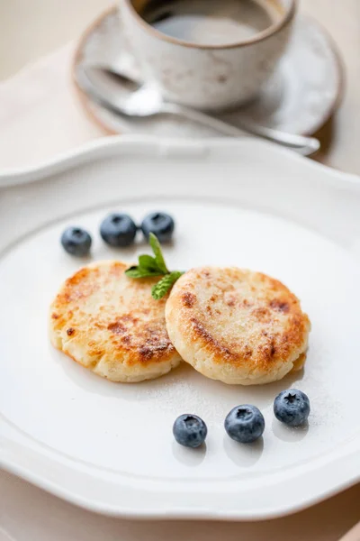 Cottage pancake o syrniki con mirtillo su piatto bianco, vista da vicino. Cucina russa, ucraina. Colazione sana e gustosa — Foto Stock