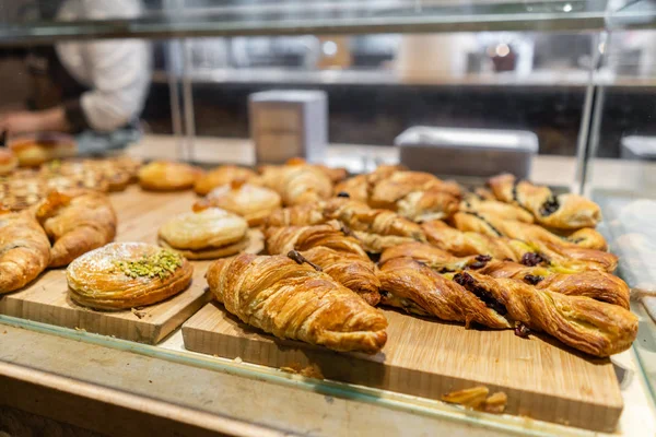 Croissant, soplos y otros pasteles. Muestra postres en una cafetería o trattoria italiana. Variedad de pasteles en exhibición . — Foto de Stock