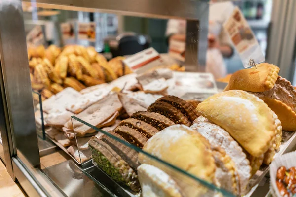 Panini, torte, biscotti e altri dolci. Vetrina i dolci in un caffè o in una trattoria italiana. Varietà di torte in mostra . — Foto Stock