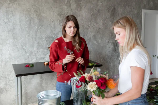 Florist arbetsplatsen. Kvinna att arrangera en bukett med rosor, krysantemum, nejlika och andra blommor. Lärare och elev till blomsterhandlare i mästarkurser eller kurser — Stockfoto