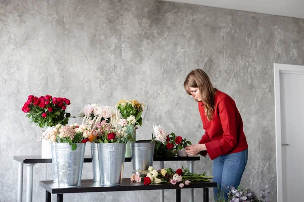 Florist arbetsplatsen. Kvinna att arrangera en bukett med rosor, krysantemum, nejlika och andra blommor. En lärare i blomsterhandlare i mästarkurser eller kurser — Stockfoto