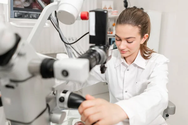 Dentista femenina usuario avanzado, herramientas dentales. Instalación de microscopio para examinar los dientes de sus pacientes. en el consultorio dental. Concepto de medicina, odontología y salud . —  Fotos de Stock