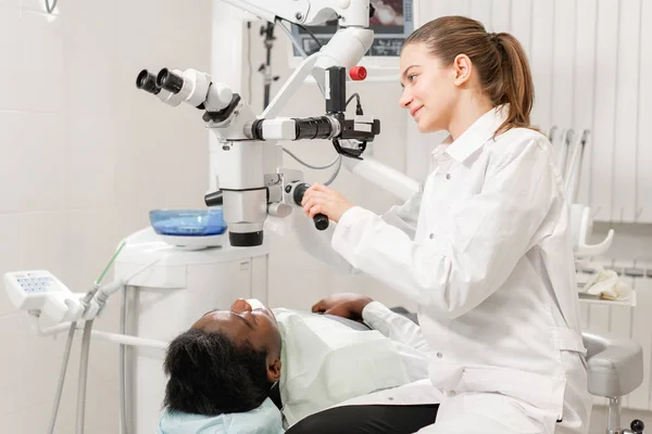 Dentista mulher usuário avançado, ferramentas dentárias. Microscópio de configuração para examinar os dentes dos pacientes. no consultório odontológico. Conceito de medicina, odontologia e cuidados de saúde . — Fotografia de Stock