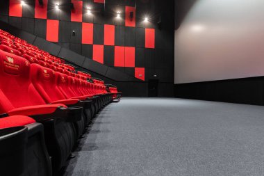 Rusya, Nizhny Novgorod - 14 Kasım 2016: Sinema Imperia Grez Nebo, Dolby atmosferini boş kırmızı sinema salonu sandalye, yumuşak ve rahat sandalyeler. Ekranda beyaz boşluk ile perspektif oditoryum görüntülemek