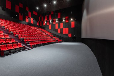 Rusya, Nizhny Novgorod - 14 Kasım 2016: Sinema Imperia Grez Nebo, Dolby atmosferini boş kırmızı sinema salonu sandalye, yumuşak ve rahat sandalyeler. Ekranda beyaz boşluk ile perspektif oditoryum görüntülemek