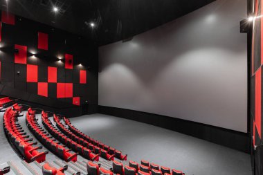 Rusya, Nizhny Novgorod - 14 Kasım 2016: Sinema Imperia Grez Nebo, Dolby atmosferini boş kırmızı sinema salonu sandalye, yumuşak ve rahat sandalyeler. Ekranda beyaz boşluk ile perspektif oditoryum görüntülemek