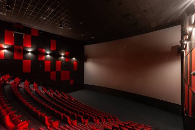 Rusya, Nizhny Novgorod - 14 Kasım 2016: Sinema Imperia Grez Nebo, Dolby atmosferini boş kırmızı sinema salonu sandalye, yumuşak ve rahat sandalyeler. Ekranda beyaz boşluk ile perspektif oditoryum görüntülemek