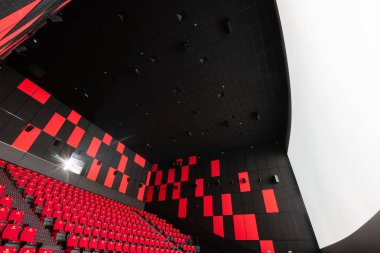 Rusya, Nizhny Novgorod - 14 Kasım 2016: Sinema Imperia Grez Nebo, Dolby atmosferini boş kırmızı sinema salonu sandalye, yumuşak ve rahat sandalyeler. Ekranda beyaz boşluk ile perspektif oditoryum görüntülemek