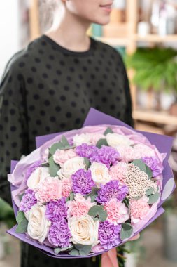 güzel taze karışık çiçekli buket kadın elinde kesilmiş. Çiçekçi Çiçek dükkanında çalışır. Hassas Pastel tonları renk