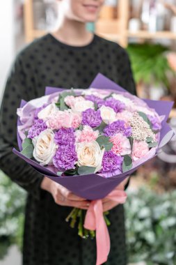 güzel taze karışık çiçekli buket kadın elinde kesilmiş. Çiçekçi Çiçek dükkanında çalışır. Hassas Pastel tonları renk
