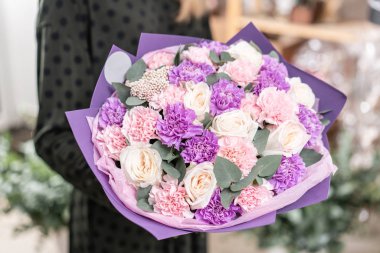güzel taze karışık çiçekli buket kadın elinde kesilmiş. Çiçekçi Çiçek dükkanında çalışır. Hassas Pastel tonları renk