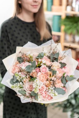 güzel taze karışık çiçekli buket kadın elinde kesilmiş. Çiçekçi Çiçek dükkanında çalışır. Hassas Pastel tonları renk