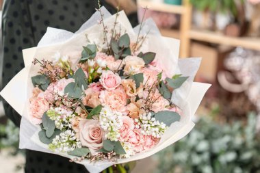 güzel taze karışık çiçekli buket kadın elinde kesilmiş. Çiçekçi Çiçek dükkanında çalışır. Hassas Pastel tonları renk