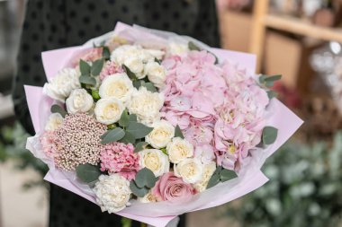 güzel taze karışık çiçekli buket kadın elinde kesilmiş. Çiçekçi Çiçek dükkanında çalışır. Hassas Pastel tonları renk