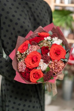güzel taze karışık çiçekli buket kadın elinde kesilmiş. Çiçekçi Çiçek dükkanında çalışır. Parlak sulu renkler