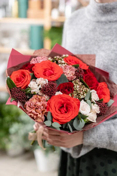 güzel taze karışık çiçekli buket kadın elinde kesilmiş. Çiçekçi Çiçek dükkanında çalışır. Parlak sulu renkler