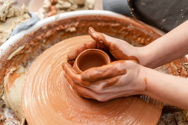 Ambachtsman handen maken van aardewerk kom. Vrouw die werkt op potter wiel. Familiebedrijf winkel beeldhouwt pot van klei weergave boven. — Stockfoto