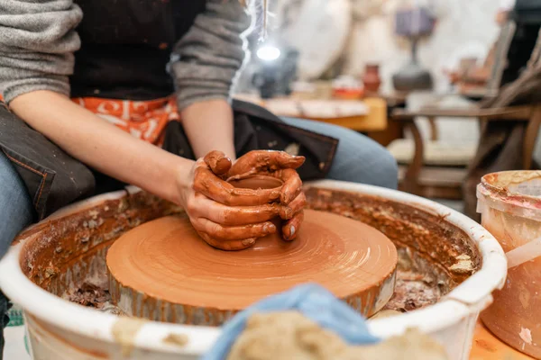 Mani artigianali che fanno vasellame. Donna che lavora alla ruota del vasaio. Negozio di famiglia scolpisce pentola da argilla vista superiore . — Foto Stock