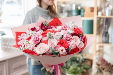 güzel taze karışık çiçekli buket kadın elinde kesilmiş. Çiçekçi Çiçek dükkanında çalışır. Kırmızı ve pembe renk