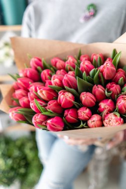 Kırmızı lale bahar buket elinde tutan genç güzel kadın. Taze kesilmiş bahar çiçek kadın elinde demet