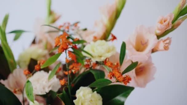 フラワーアレンジメントをクローズ アップ。ガラス花瓶の花。女性新鮮な花を摘んで花瓶に美しい花束を作成します。フラワー ショップ コンセプト — ストック動画