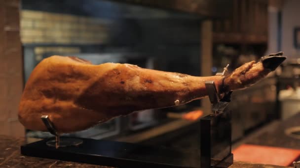 Close-up jamon. professional cutter carving slices from a whole bone-in serrano ham — Stock Video