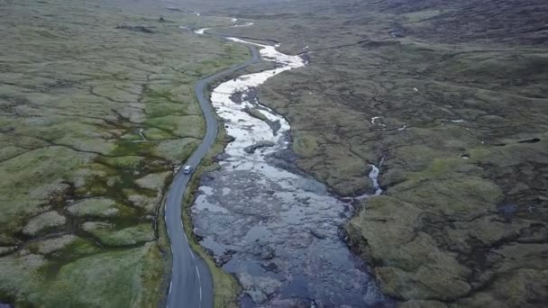 Îles de l'Atlantique Nord au coucher du soleil. La voiture part sur la route le long de la côte, prise de vue depuis le quadrocopter — Video