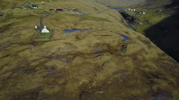 Liten by kyrka i Saksun och en närliggande sjö som ligger på ön av Streymoy, Färöarna, Danmark. Skytte en drone quadrocopter, — Stockvideo