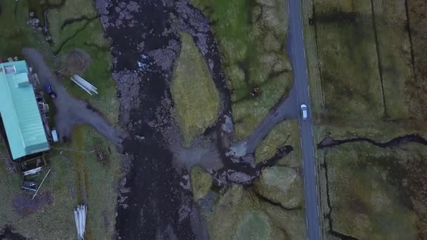 Denemarken, Faeröer - mei, 14 2017: Noord-Atlantische eilanden in de zonsondergang. De auto gaat op de weg langs de kust, schieten uit de quadrocopter — Stockvideo