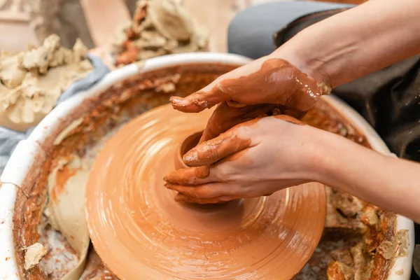 Mani artigianali che fanno vasellame. Donna che lavora alla ruota del vasaio. Negozio di famiglia scolpisce pentola da argilla vista superiore . — Foto Stock