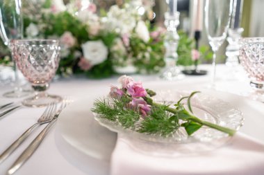 Closeup sofra plakaları ve sofra, çiçeklerle süslenmiş. Çiçek dekorasyon düğün töreni romantik yemek için. Düğün Ziyafet, Festival dekor. Servis ve ikram konsepti.