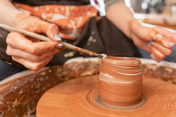 Mãos de artesão fazendo tigela de cerâmica. Mulher a trabalhar na roda de oleiro. Família loja de negócios esculpe pote de argila vista topo . — Fotografia de Stock