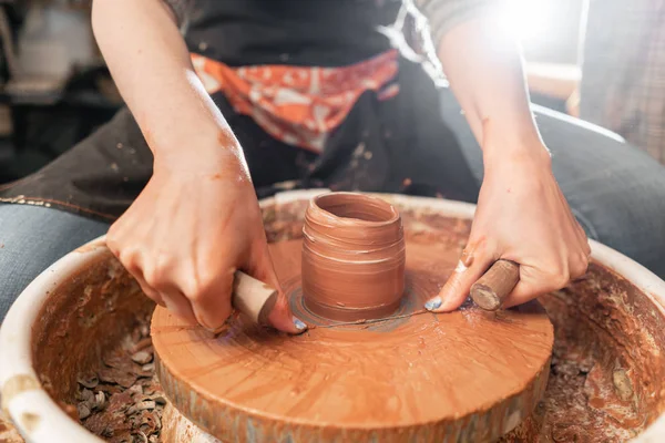 Bezuinigingen van product met draad. Ambachtsman handen maken van aardewerk kom. Vrouw die werkt op potter wiel. Familiebedrijf winkel beeldhouwt pot van klei weergave boven. — Stockfoto