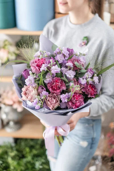 Hermoso ramo fresco cortado de flores mixtas en mano de mujer. el trabajo de la floristería en una florería. Humor de primavera — Foto de Stock